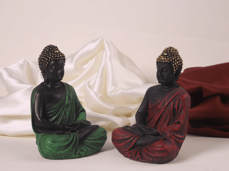 red and green meditating buddha pair side view